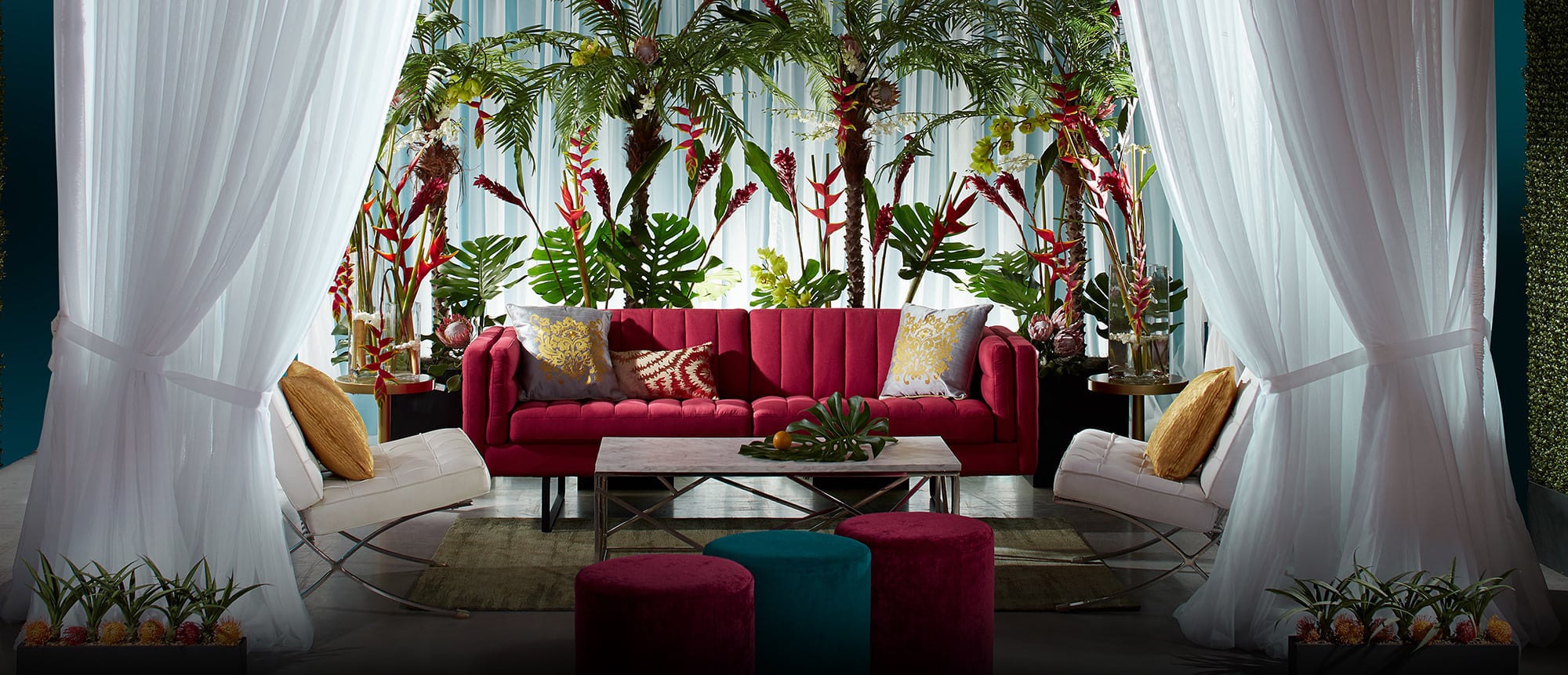 White drape cabana with red sofa and ottomans