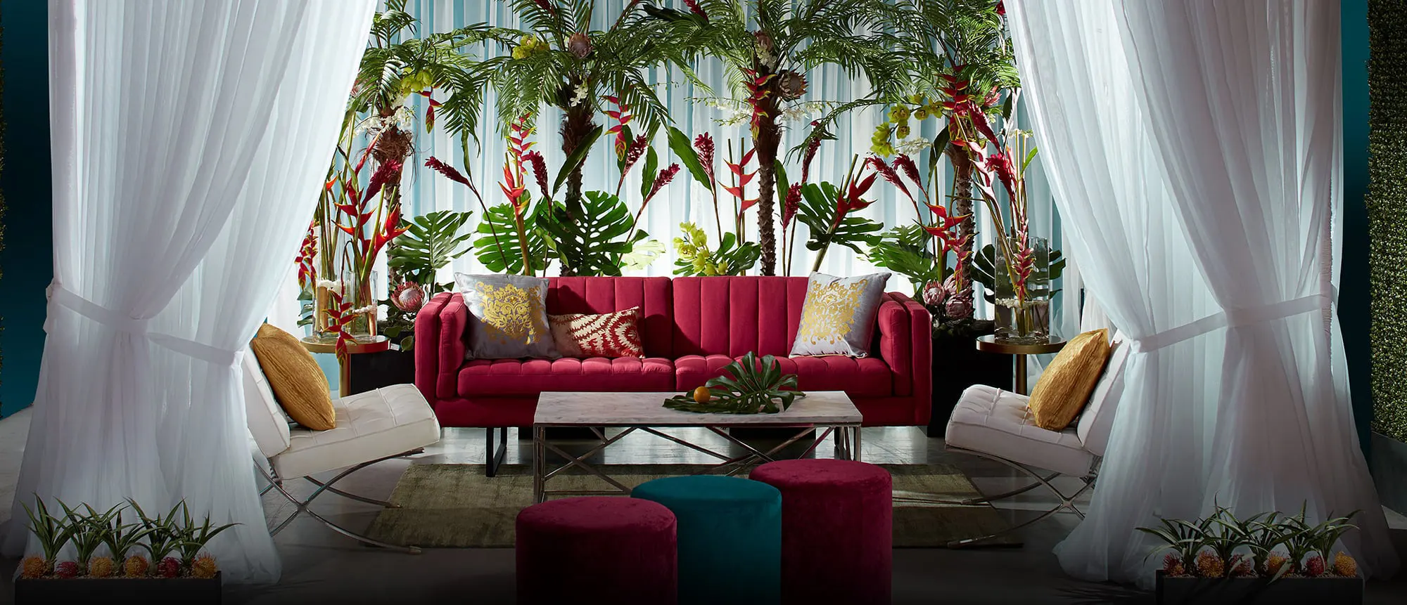 White drape cabana with red sofa and ottomans